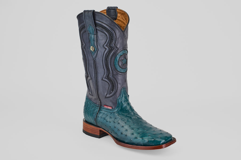 The Austin - Gasoline Green Square Toe men's western boot features a turquoise ostrich leather foot, dark blue leather shaft with decorative stitching, square toe, and wooden heel, shown on a plain white background.